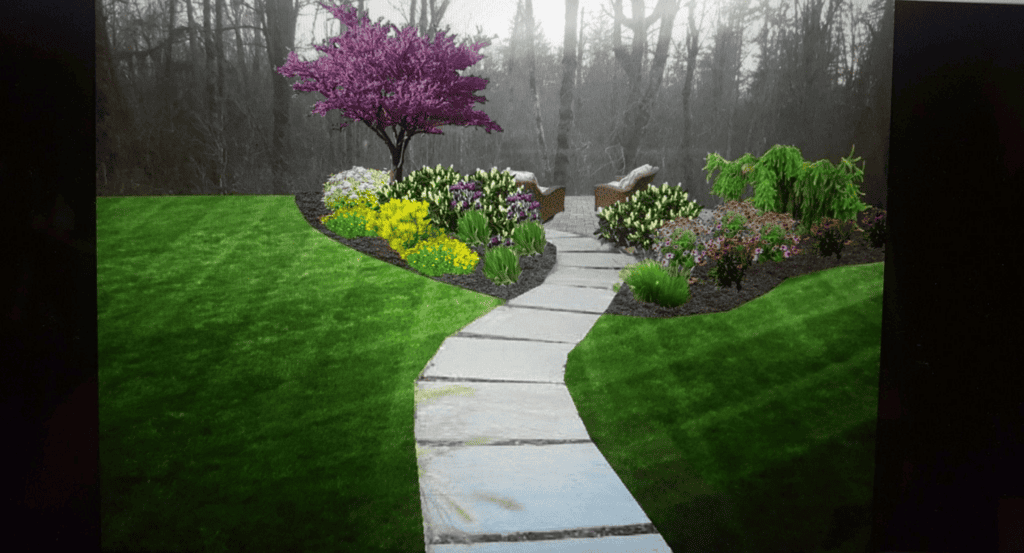 A stone pathway curves through a green lawn toward a garden with colorful flowers, bushes, and a blooming tree. Two chairs sit beside the flowers, with leafless trees in the background.